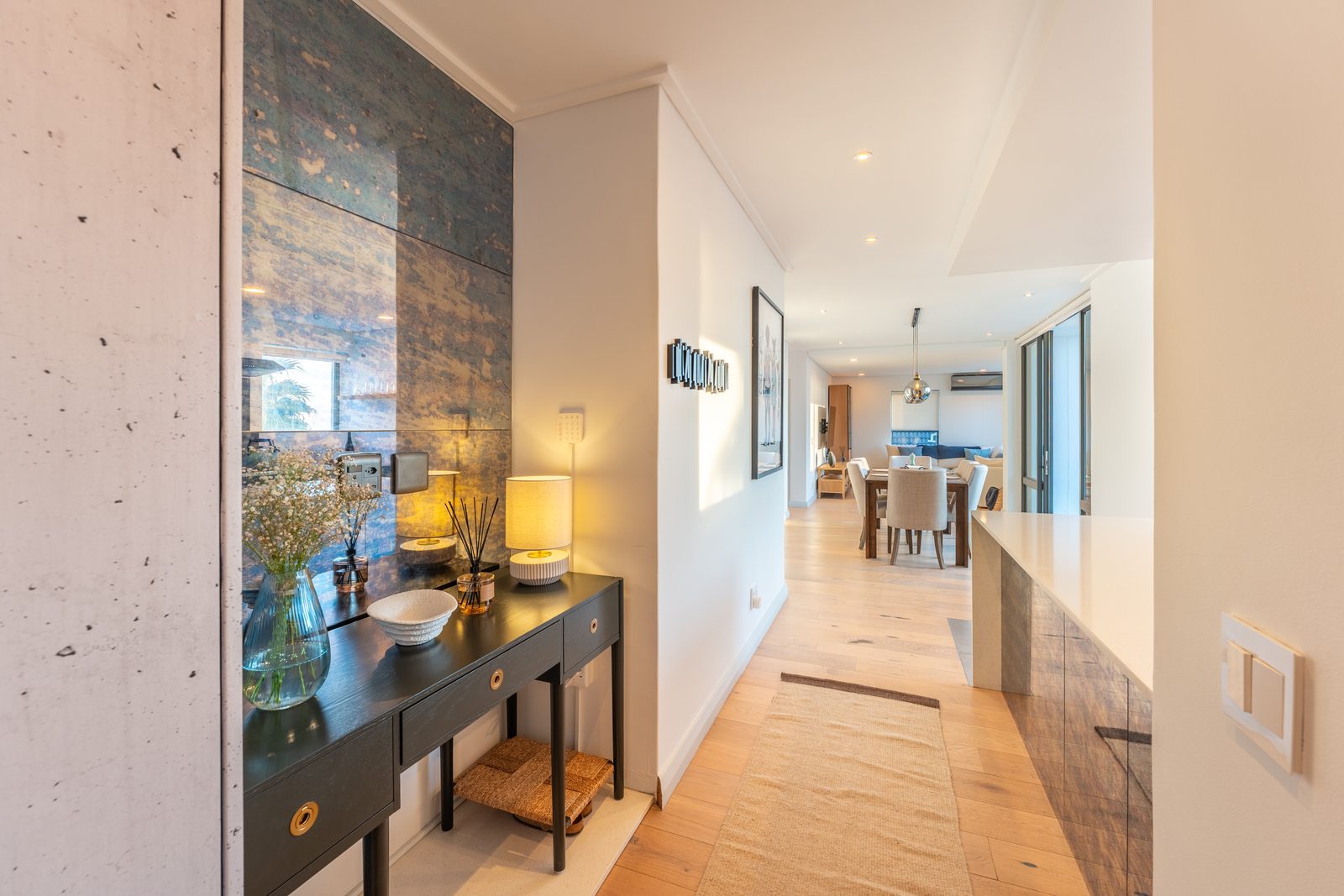 Entrance hall with a dark console table and lamps leading to the dining area